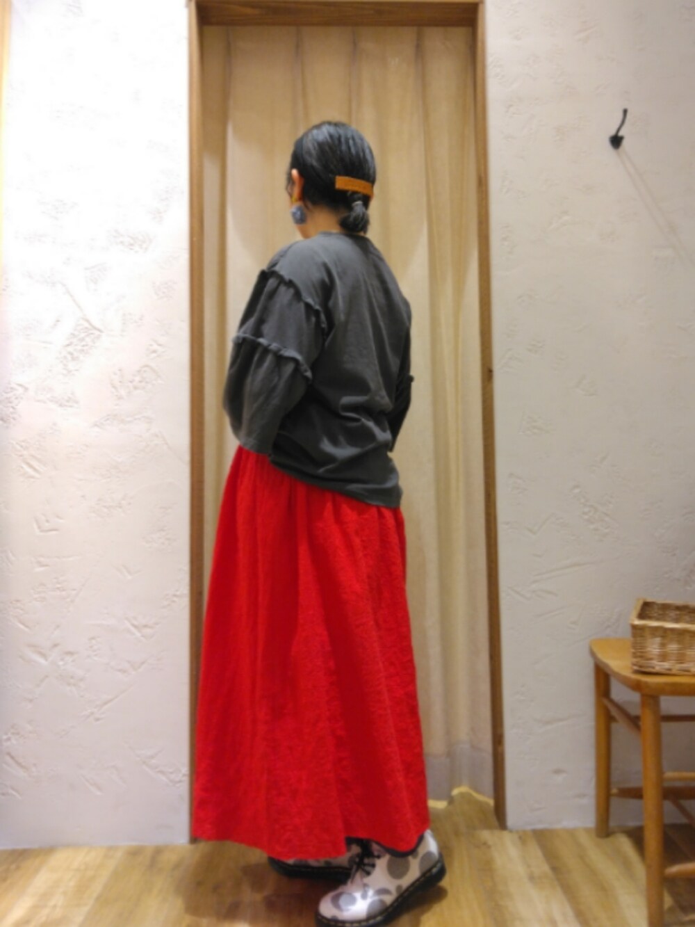 レッド系のスカート、グレー系のTシャツ/カットソーを着用したレディースの春コーディネートの2枚目の写真