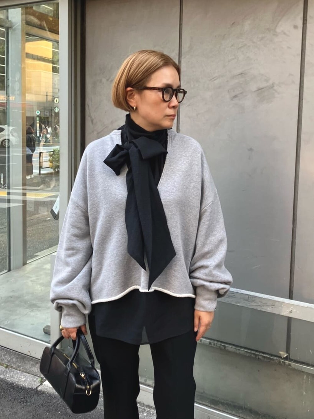 ブラック系のシャツ/ブラウス、グレー系のスウェット、ブラック系のスラックスを着用したレディースの春コーディネートの2枚目の写真