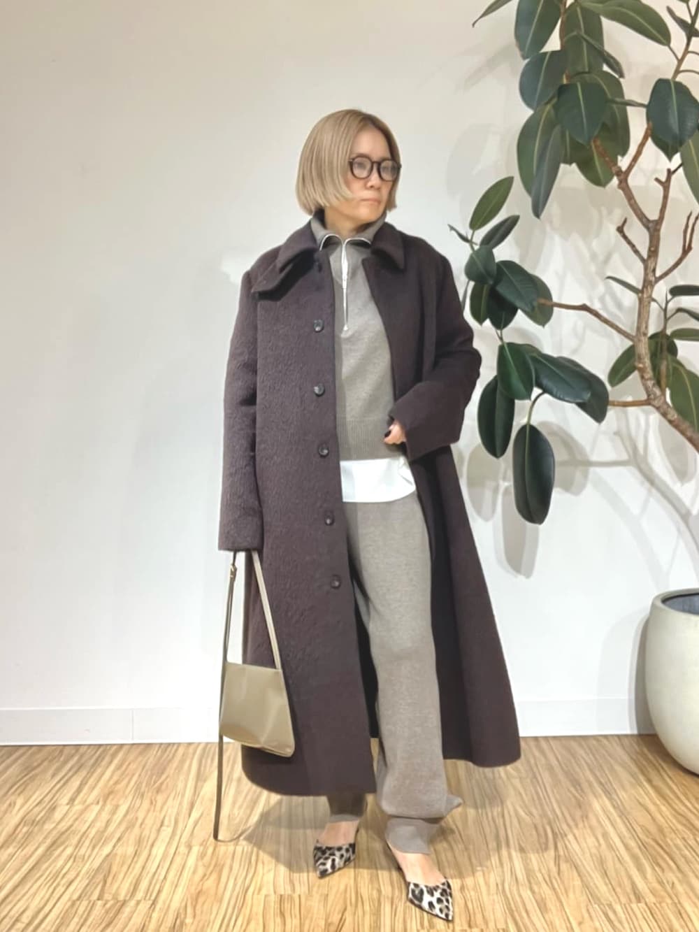 ブラウン系のステンカラーコート、ブラウン系のその他パンツ、ブラウン系のニット/セーターを着用したレディースの秋コーディネートの4枚目の写真
