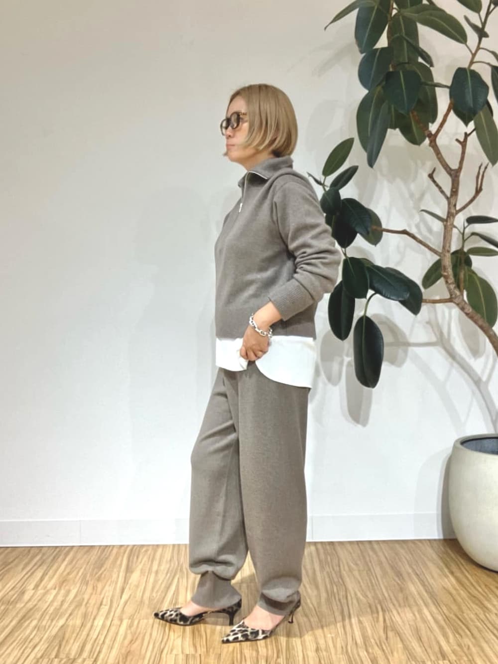 ブラウン系のステンカラーコート、ブラウン系のその他パンツ、ブラウン系のニット/セーターを着用したレディースの秋コーディネートの3枚目の写真