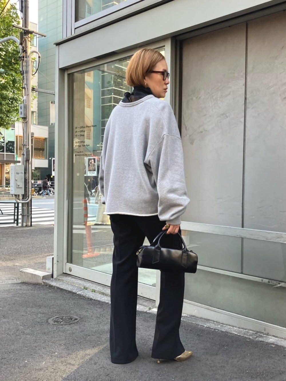 ブラック系のシャツ/ブラウス、グレー系のスウェット、ブラック系のスラックスを着用したレディースの春コーディネートの6枚目の写真