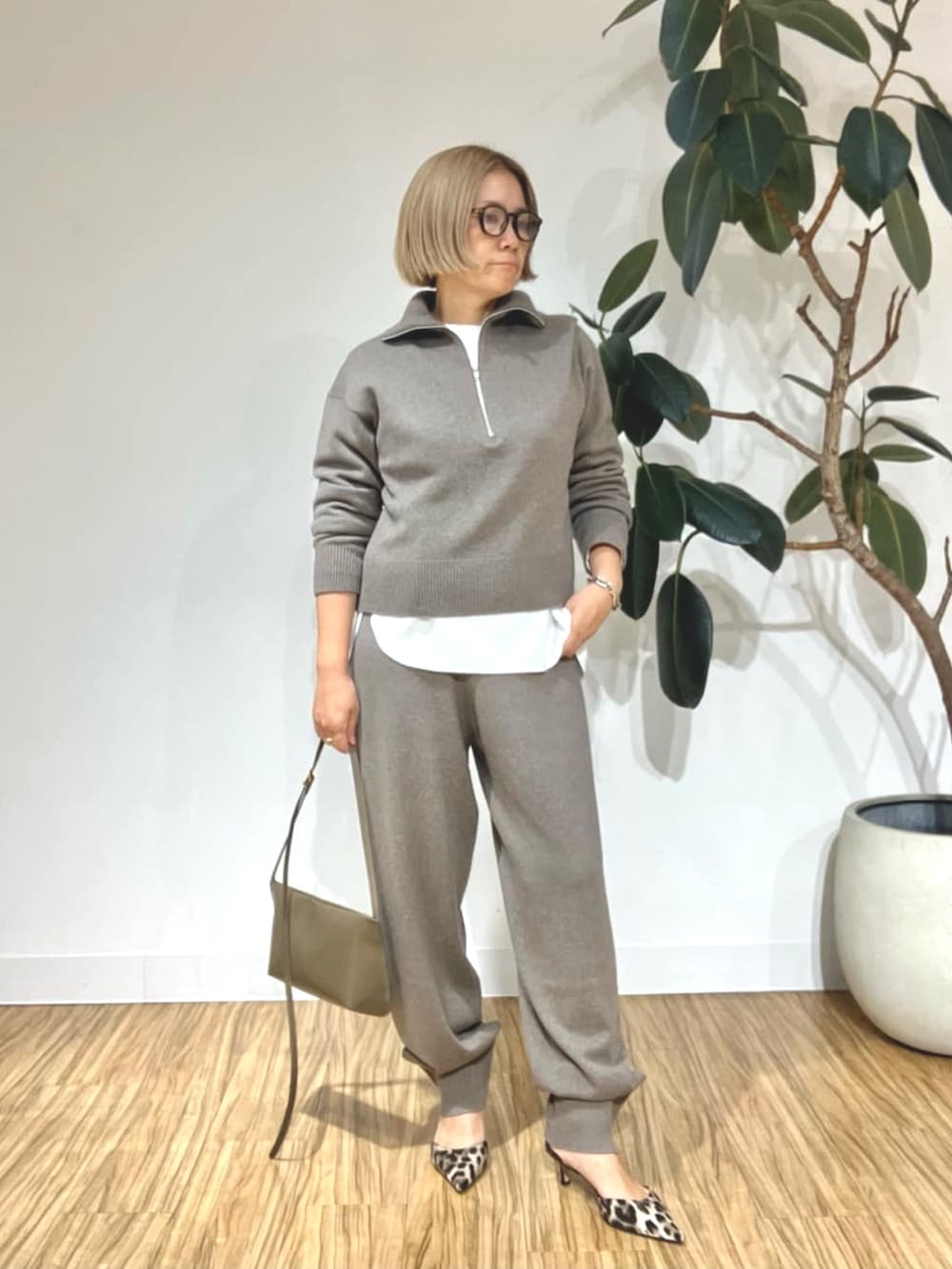 ブラウン系のステンカラーコート、ブラウン系のその他パンツ、ブラウン系のニット/セーターを着用したレディースの秋コーディネートの2枚目の写真