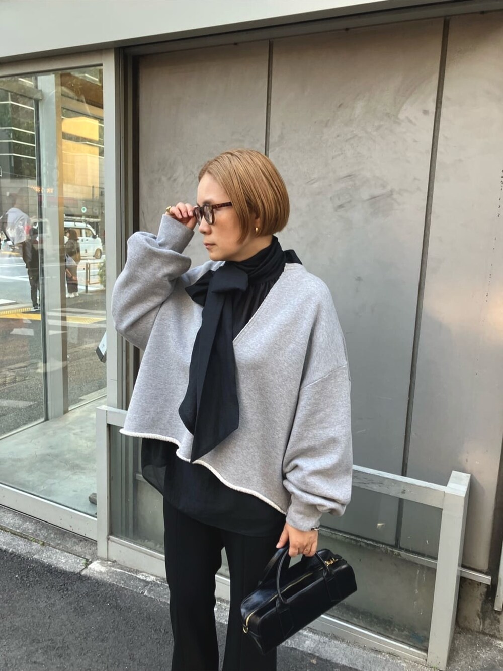 ブラック系のシャツ/ブラウス、グレー系のスウェット、ブラック系のスラックスを着用したレディースの春コーディネートの5枚目の写真