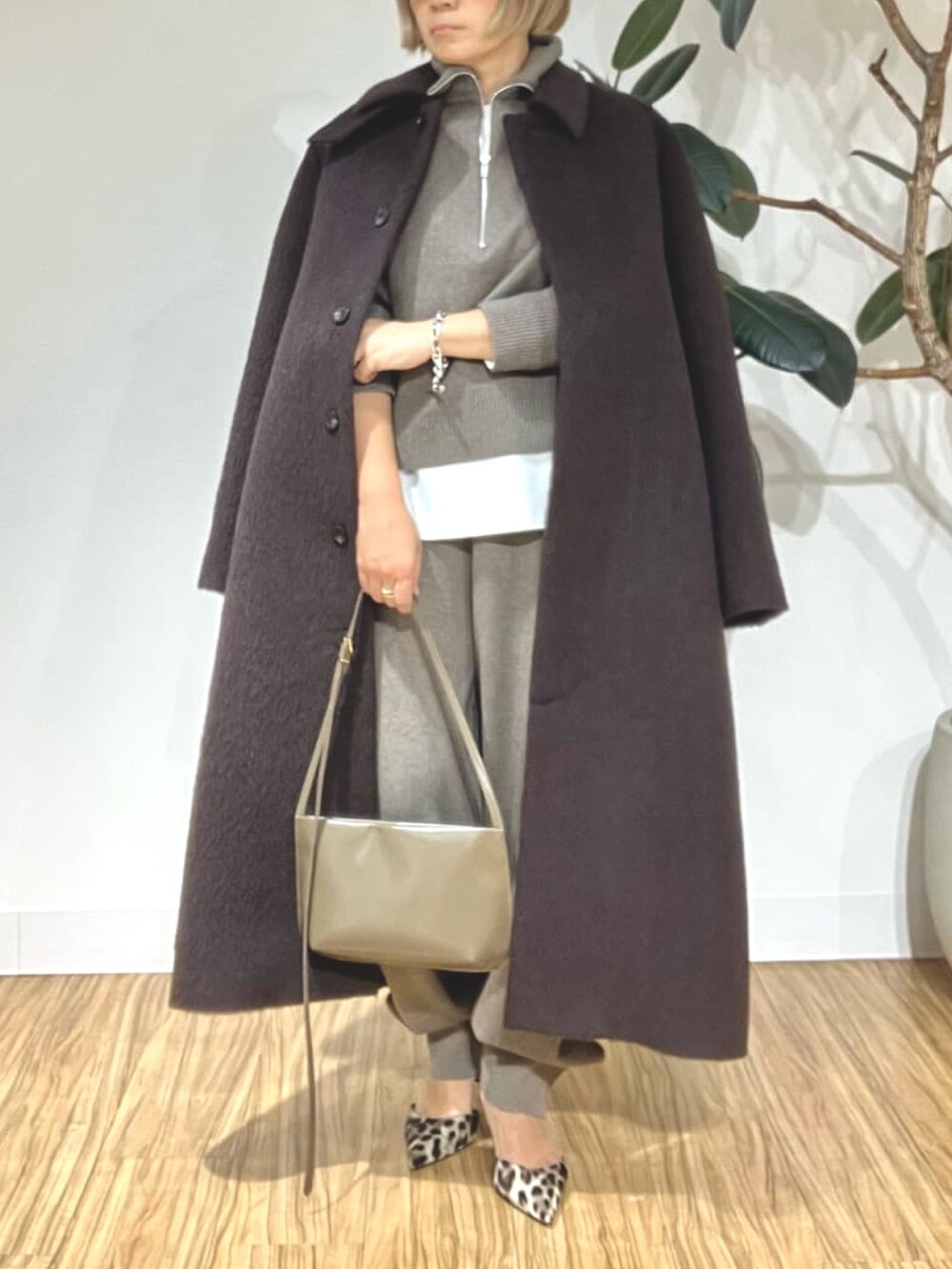 ブラウン系のステンカラーコート、ブラウン系のその他パンツ、ブラウン系のニット/セーターを着用したレディースの秋コーディネートの5枚目の写真