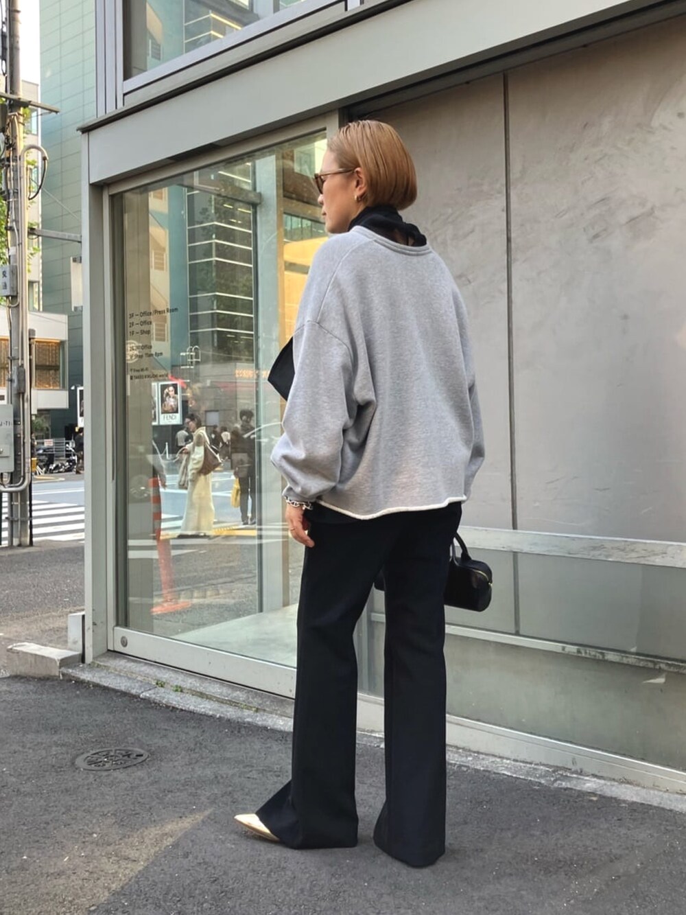 ブラック系のシャツ/ブラウス、グレー系のスウェット、ブラック系のスラックスを着用したレディースの春コーディネートの7枚目の写真