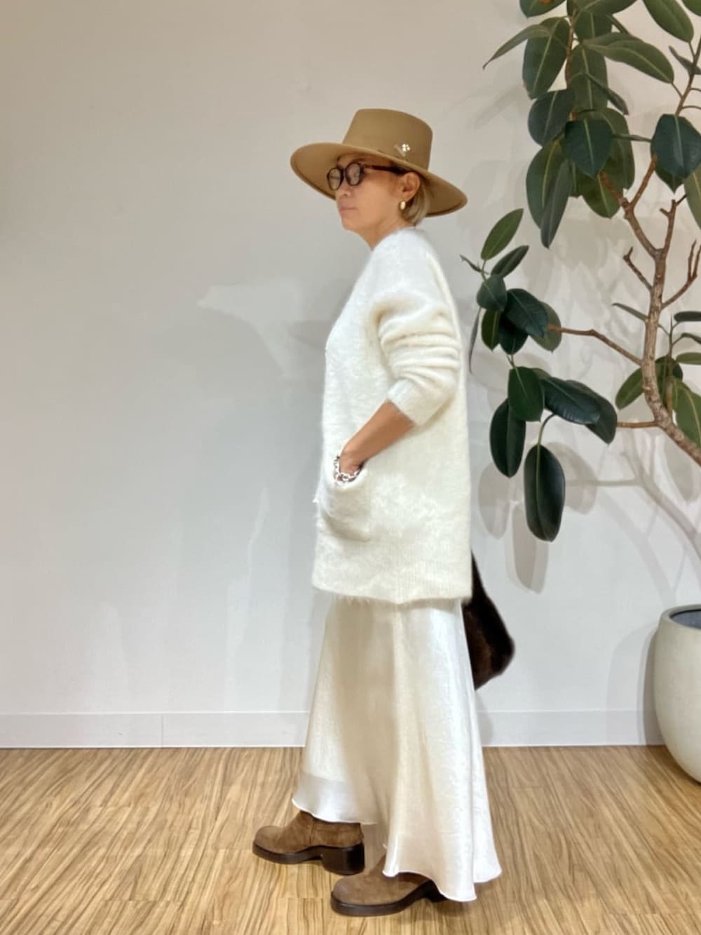 ホワイト系のキャミソール、ホワイト系のカーディガン/ボレロ、ホワイト系のスカートを着用したレディースの秋コーディネートの6枚目の写真