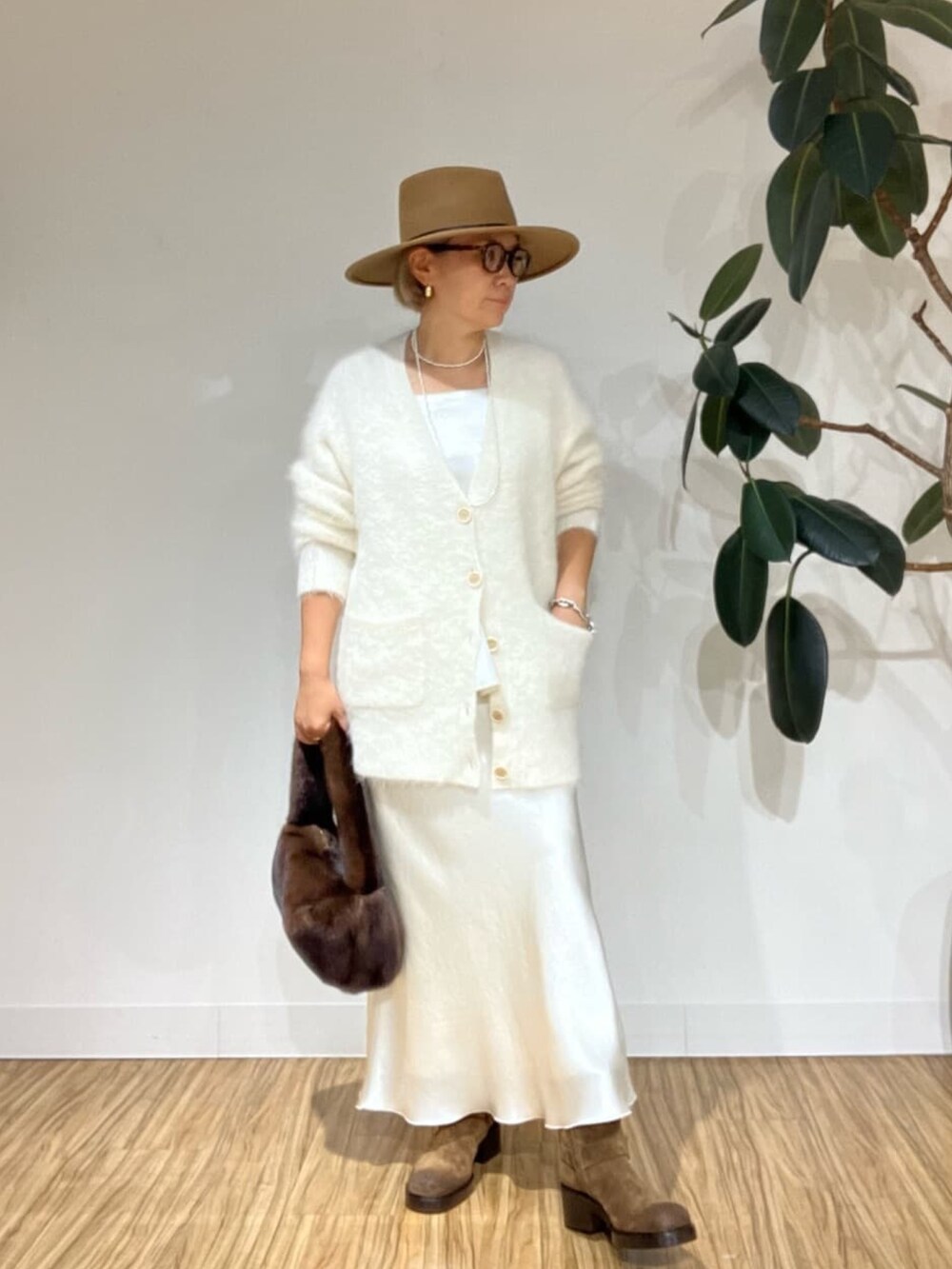 ホワイト系のキャミソール、ホワイト系のカーディガン/ボレロ、ホワイト系のスカートを着用したレディースの秋コーディネートの3枚目の写真