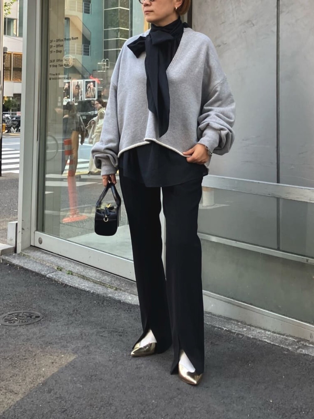 ブラック系のシャツ/ブラウス、グレー系のスウェット、ブラック系のスラックスを着用したレディースの春コーディネートの4枚目の写真