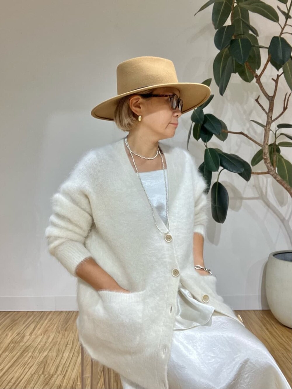 ホワイト系のキャミソール、ホワイト系のカーディガン/ボレロ、ホワイト系のスカートを着用したレディースの秋コーディネートの2枚目の写真