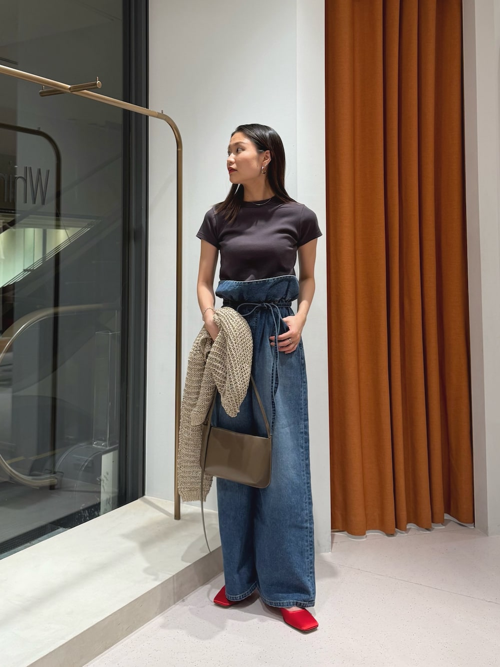 レッド系のサンダル、ブルー系のデニムパンツ、グレー系のTシャツ/カットソーを着用したレディースの冬コーディネートの3枚目の写真