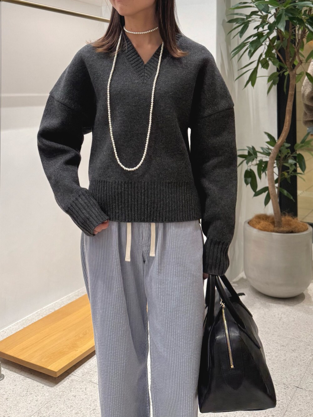 ブラック系のパンプス、ブラック系のトートバッグ、ブルー系のその他パンツを着用したレディースの秋コーディネートの6枚目の写真