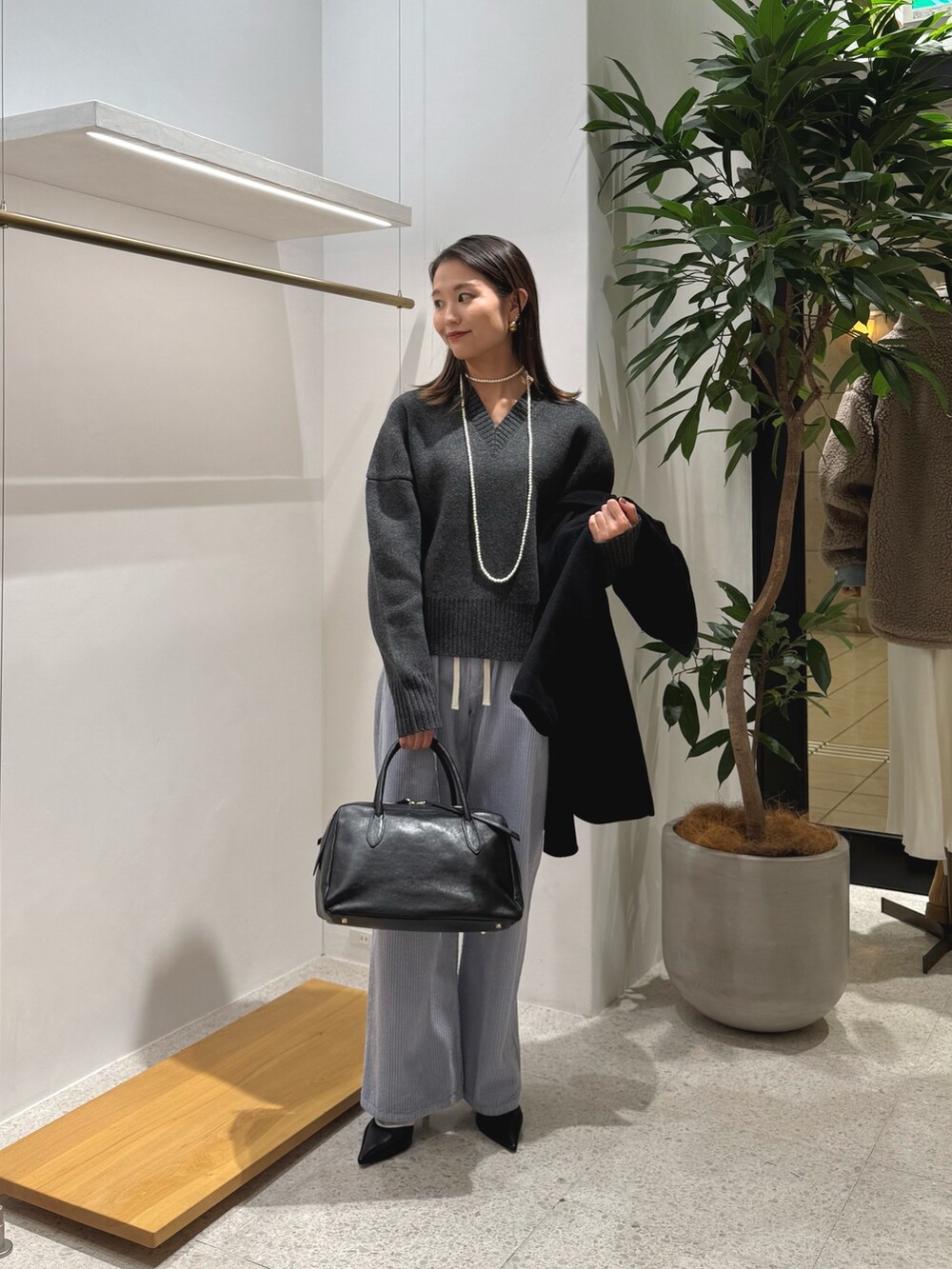 ブラック系のパンプス、ブラック系のトートバッグ、ブルー系のその他パンツを着用したレディースの秋コーディネートの5枚目の写真