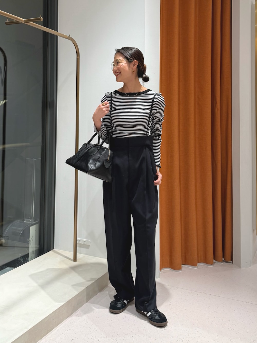 ブルー系のスラックス、ブラック系のトートバッグ、ブラック系のTシャツ/カットソーを着用したレディースの冬コーディネートの2枚目の写真