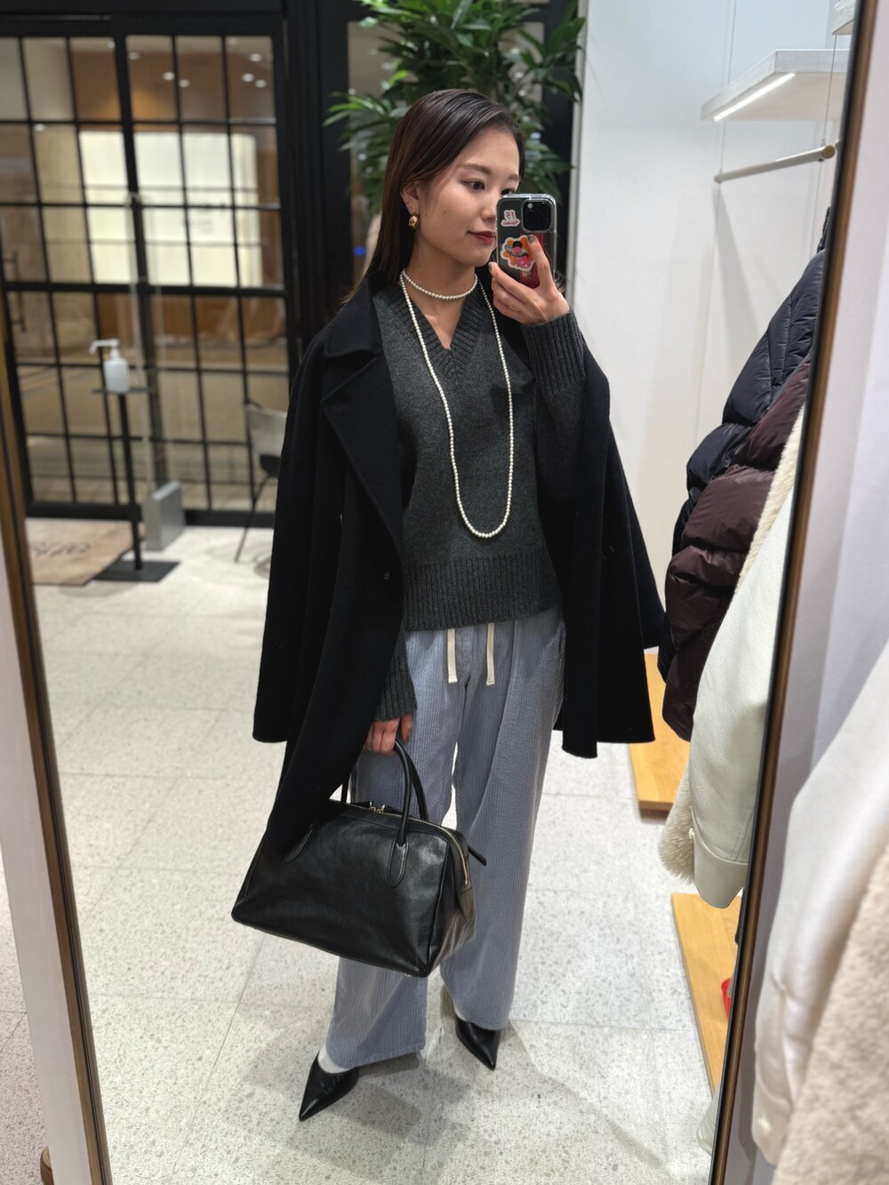 ブラック系のパンプス、ブラック系のトートバッグ、ブルー系のその他パンツを着用したレディースの秋コーディネートの7枚目の写真