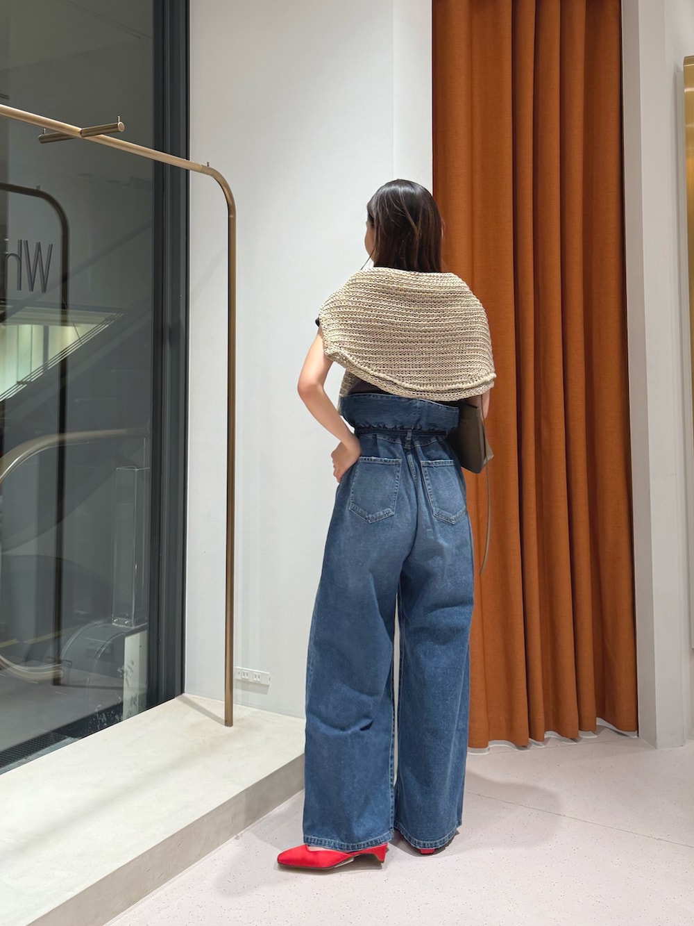 レッド系のサンダル、ブルー系のデニムパンツ、グレー系のTシャツ/カットソーを着用したレディースの冬コーディネートの4枚目の写真