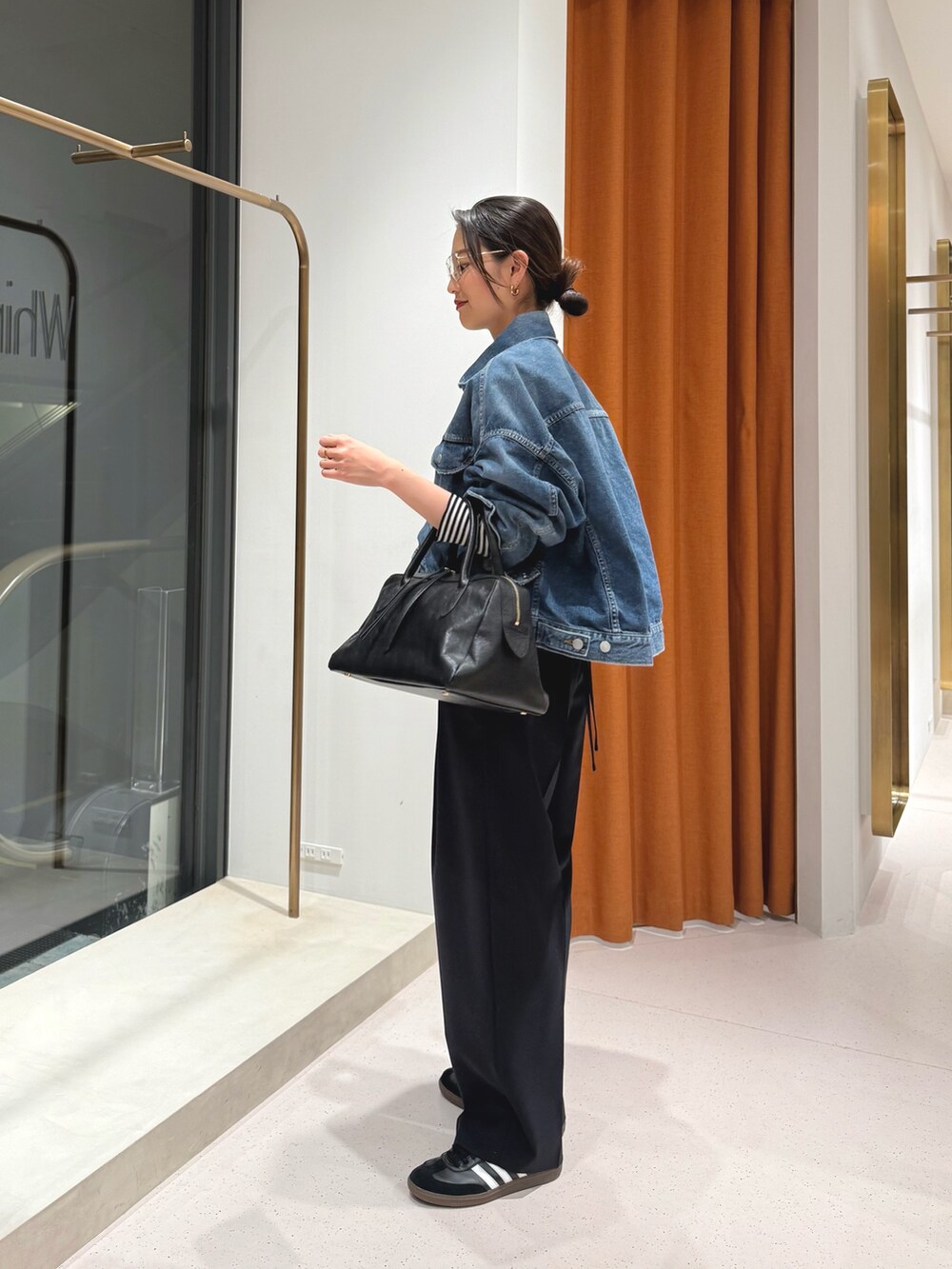ブルー系のスラックス、ブラック系のトートバッグ、ブラック系のTシャツ/カットソーを着用したレディースの冬コーディネートの7枚目の写真