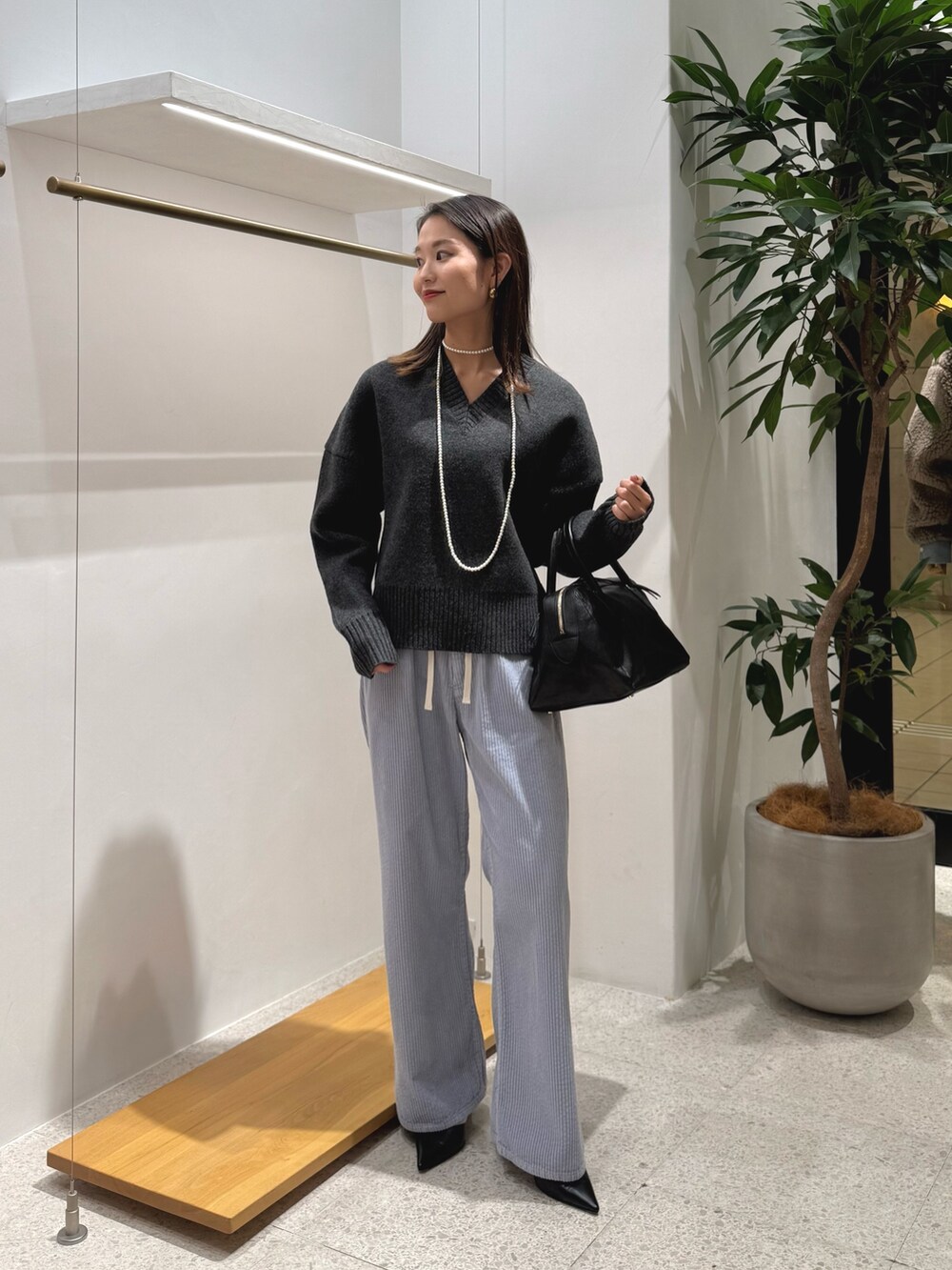 ブラック系のパンプス、ブラック系のトートバッグ、ブルー系のその他パンツを着用したレディースの秋コーディネートの4枚目の写真