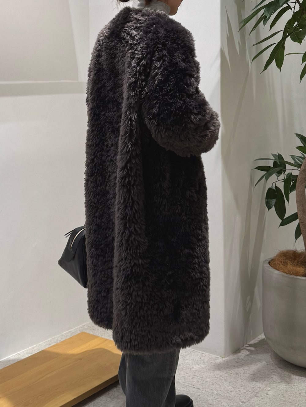 ブラック系のブーツ、グレー系のデニムパンツ、ブラック系のトートバッグを着用したレディースの秋コーディネートの3枚目の写真