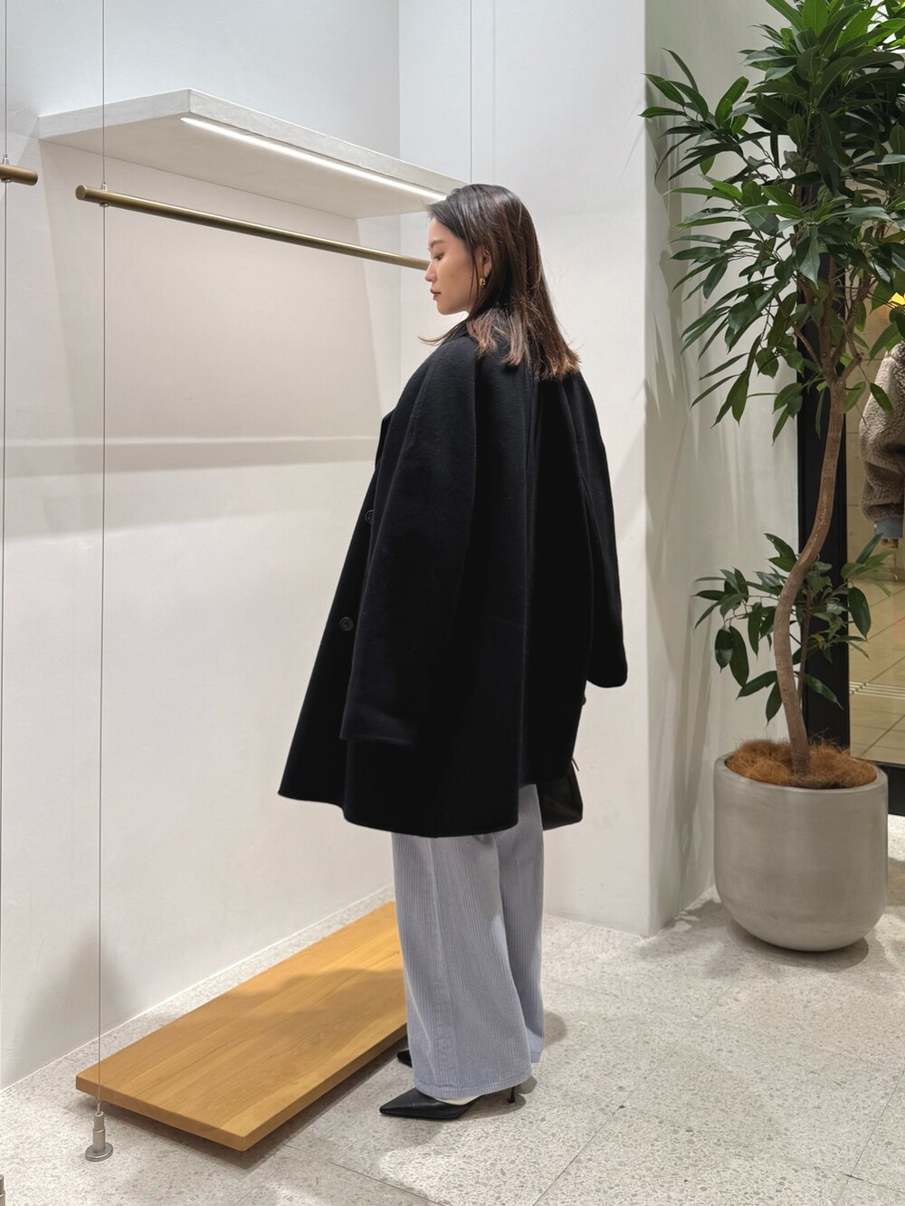 ブラック系のパンプス、ブラック系のトートバッグ、ブルー系のその他パンツを着用したレディースの秋コーディネートの2枚目の写真