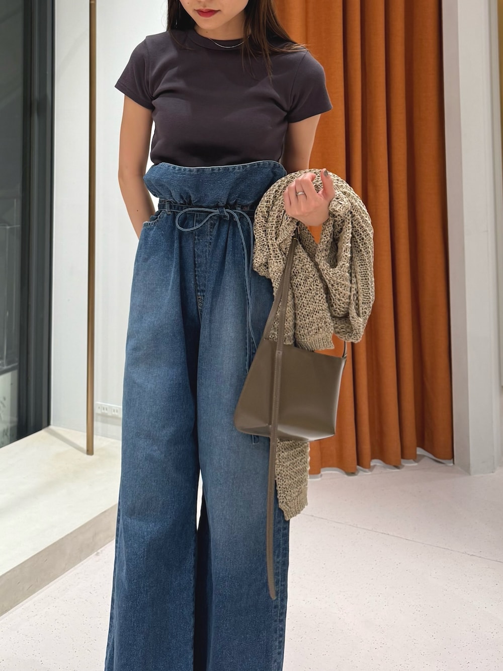 レッド系のサンダル、ブルー系のデニムパンツ、グレー系のTシャツ/カットソーを着用したレディースの冬コーディネートの2枚目の写真