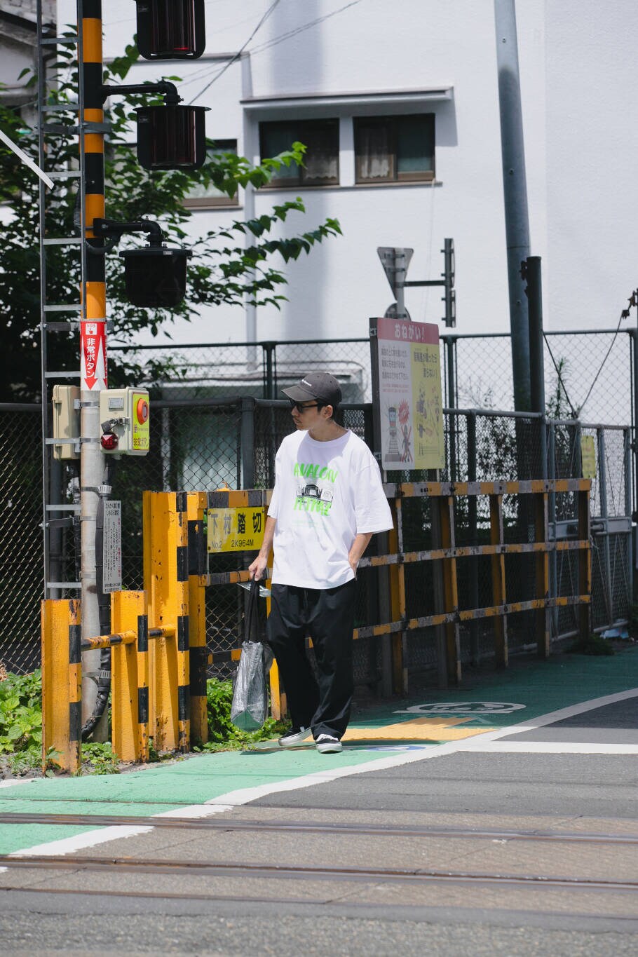 ブルー系のその他パンツ、ブラック系のトートバッグ、ホワイト系のTシャツ/カットソーを着用したメンズの夏コーディネートの7枚目の写真