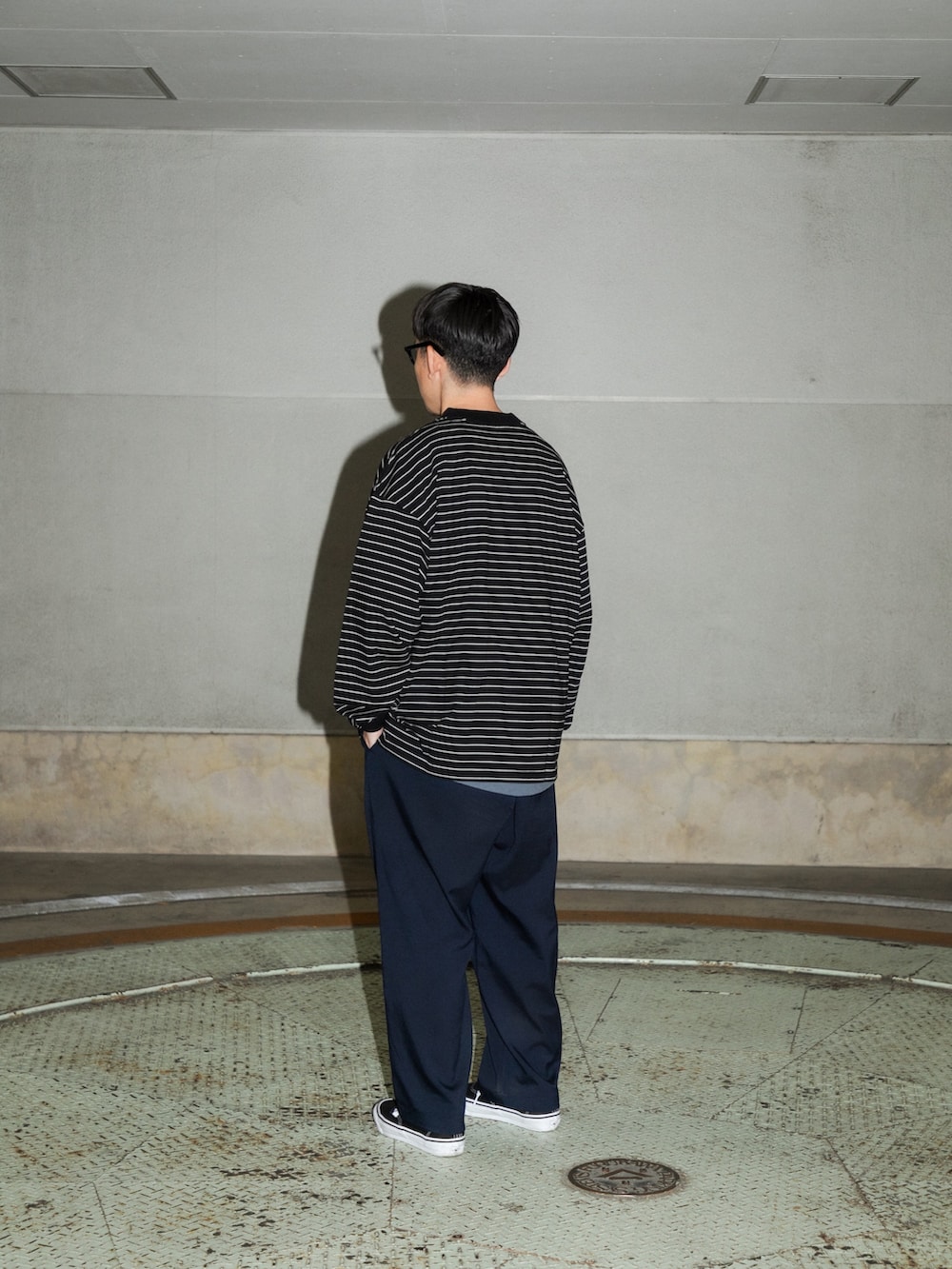 ブラック系のTシャツ/カットソー、ブルー系のその他パンツ、ブラック系のスニーカーを着用したメンズの冬コーディネートの2枚目の写真