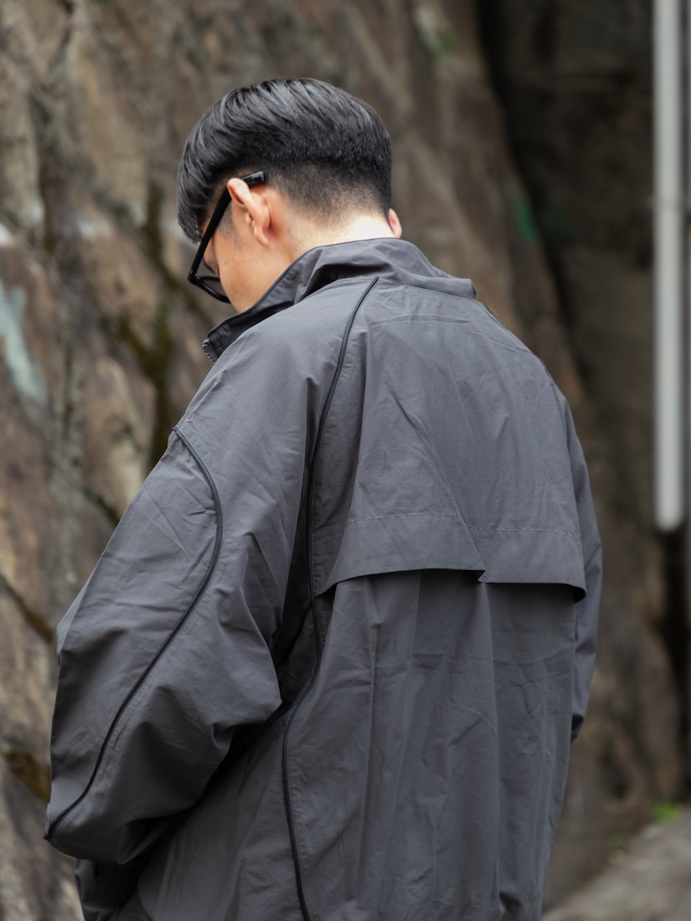 グレー系のブルゾン、ブルー系のその他パンツ、ブラック系のスニーカーを着用したメンズの冬コーディネートの5枚目の写真