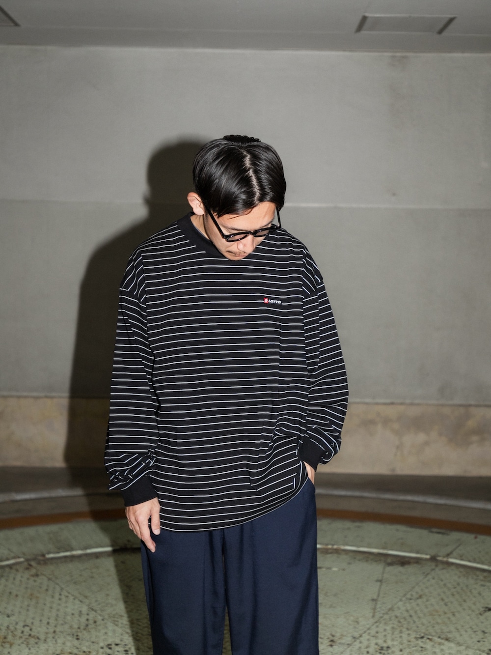 ブラック系のTシャツ/カットソー、ブルー系のその他パンツ、ブラック系のスニーカーを着用したメンズの冬コーディネートの4枚目の写真