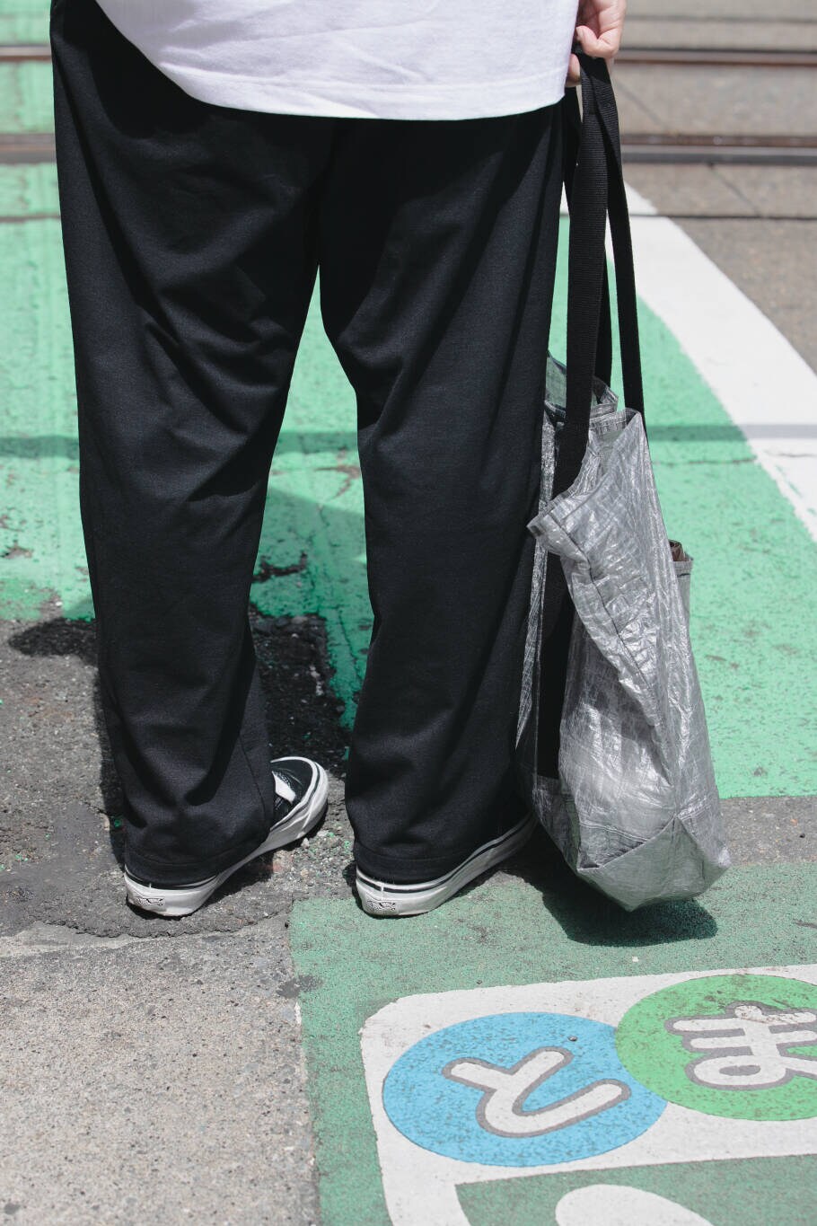 ブルー系のその他パンツ、ブラック系のトートバッグ、ホワイト系のTシャツ/カットソーを着用したメンズの夏コーディネートの6枚目の写真