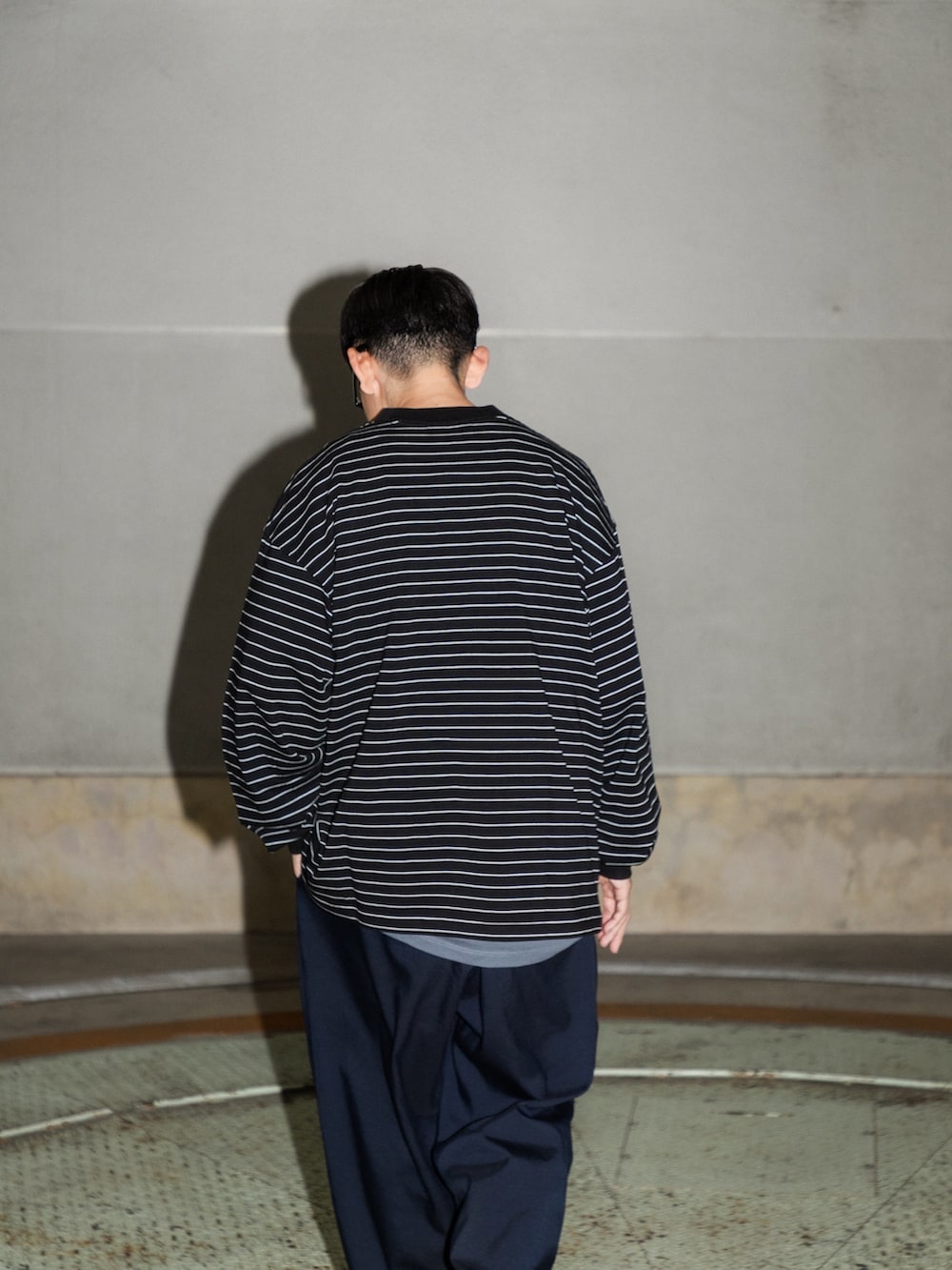 ブラック系のTシャツ/カットソー、ブルー系のその他パンツ、ブラック系のスニーカーを着用したメンズの冬コーディネートの5枚目の写真