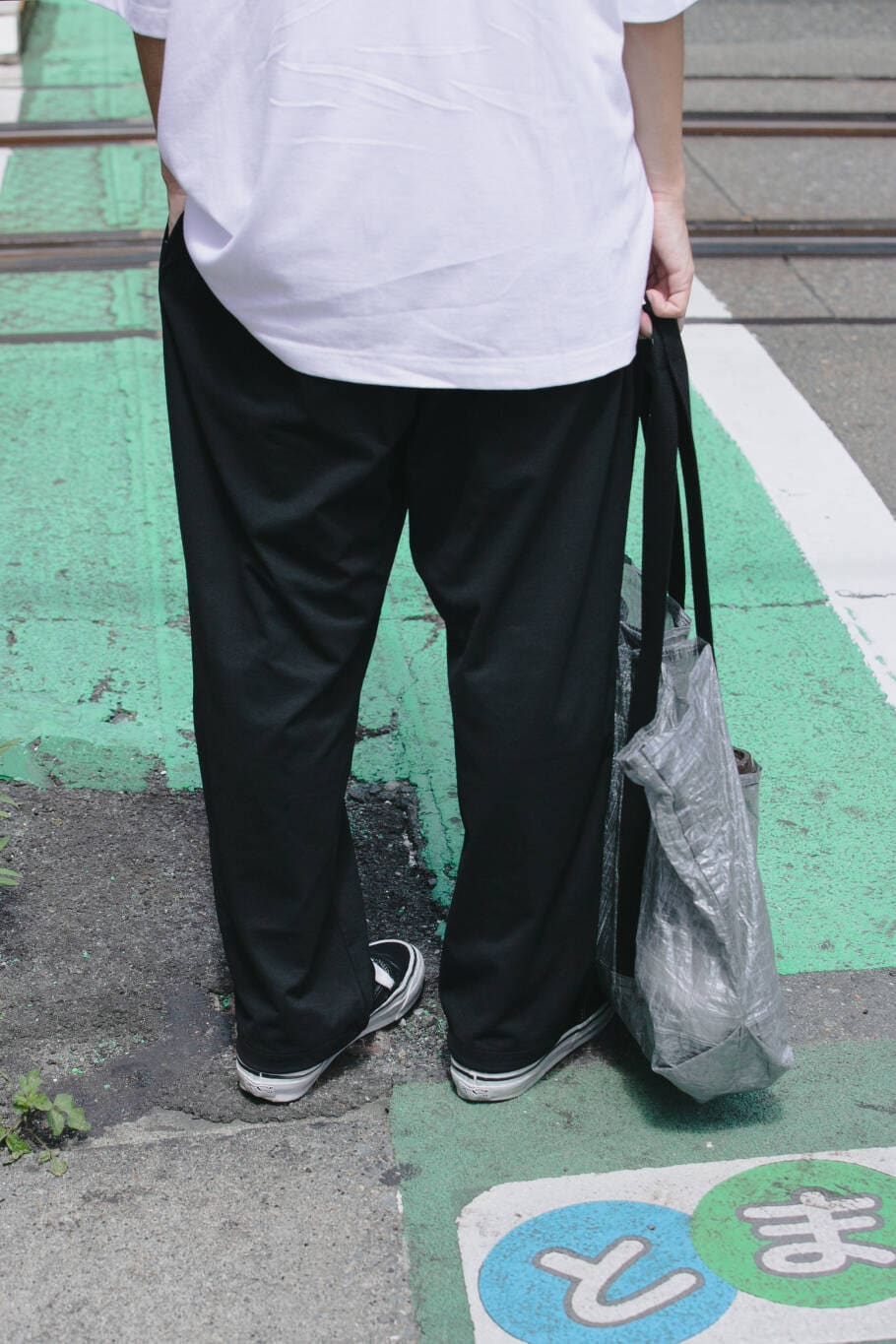 ブルー系のその他パンツ、ブラック系のトートバッグ、ホワイト系のTシャツ/カットソーを着用したメンズの夏コーディネートの5枚目の写真