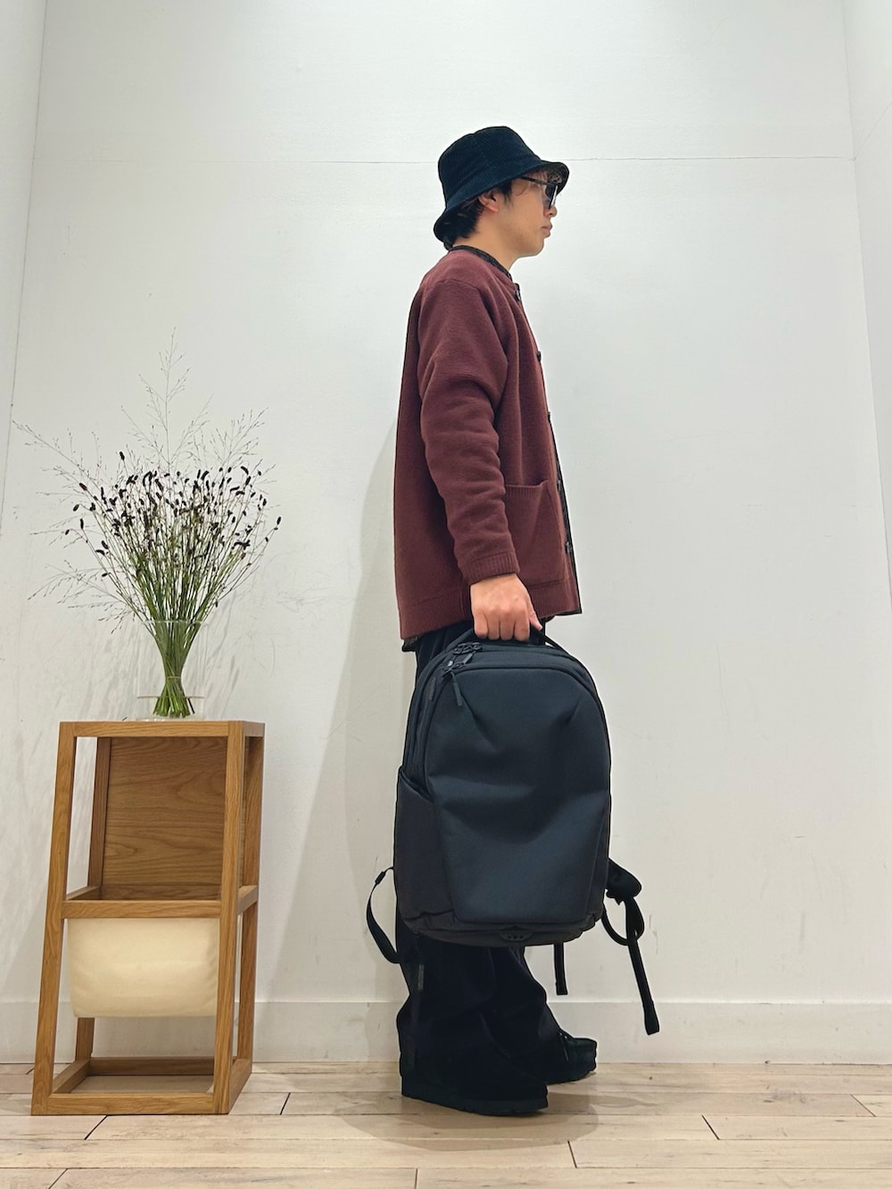 レッド系のカーディガン/ボレロ、ブラウン系のシャツ/ブラウス、ブラック系のスラックスを着用したメンズの秋コーディネートの4枚目の写真