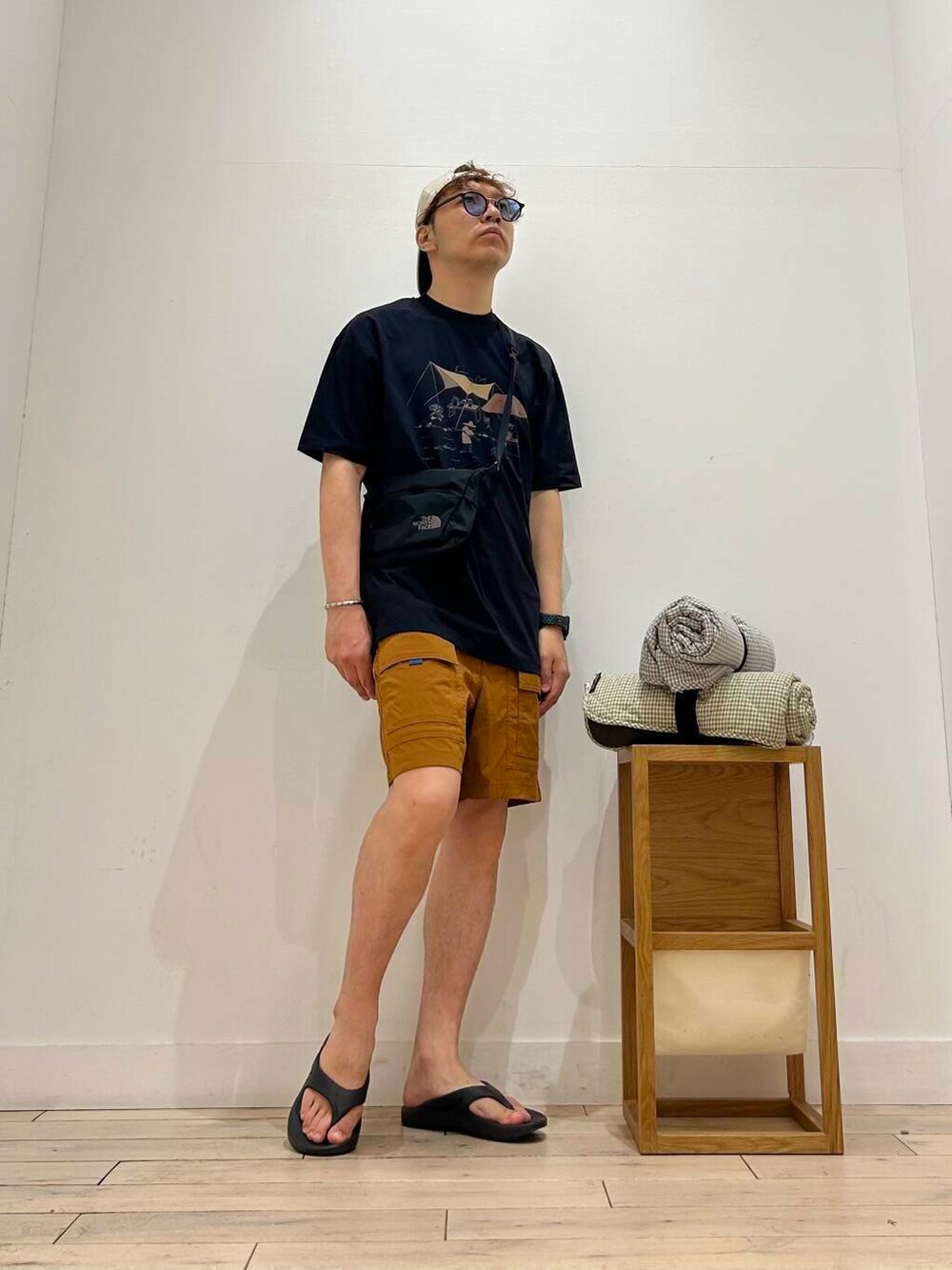 ブラック系のサンダル、ブラック系のTシャツ/カットソー、パープル系のラグ/マットを着用したメンズの夏コーディネートの3枚目の写真