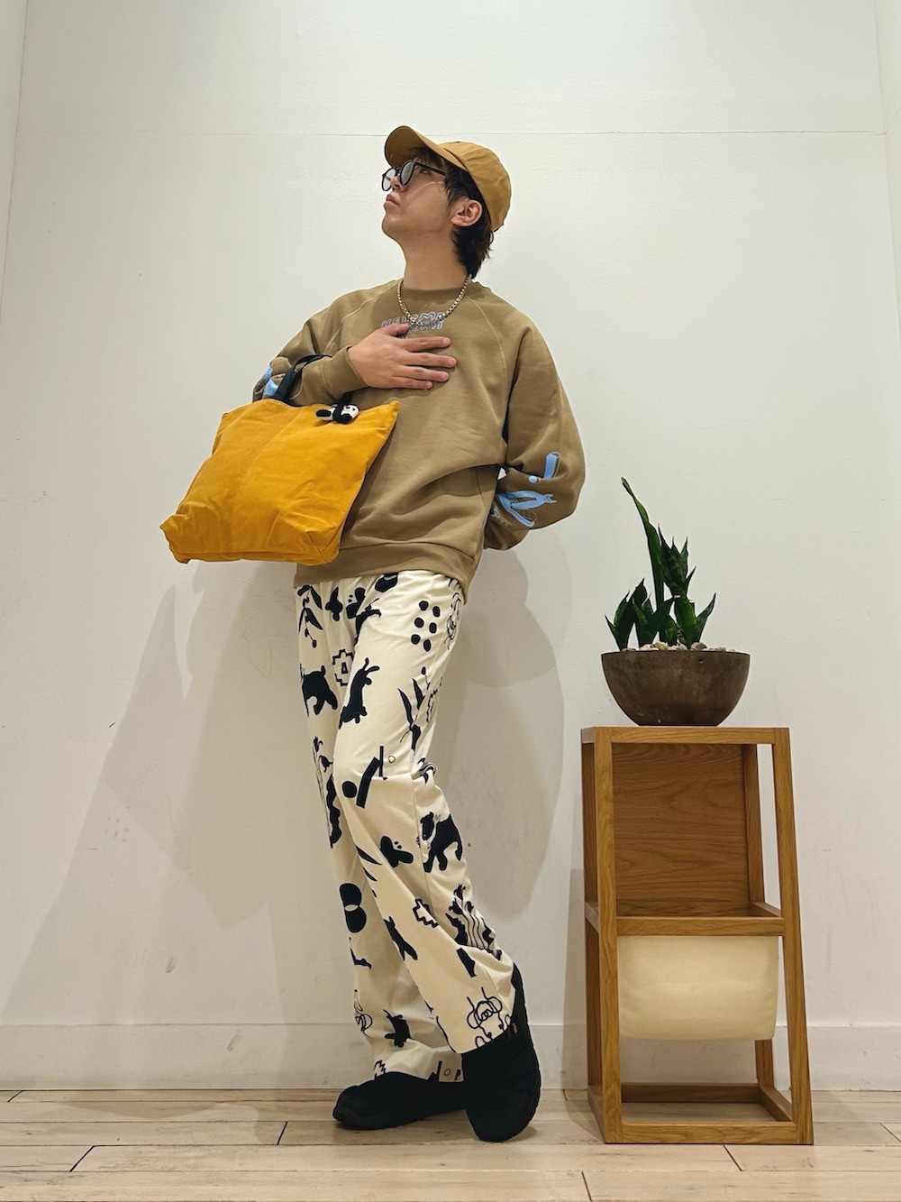 ホワイト系のその他パンツ、ブラック系のスリッポン、イエロー系のトートバッグを着用したメンズの秋コーディネートの2枚目の写真