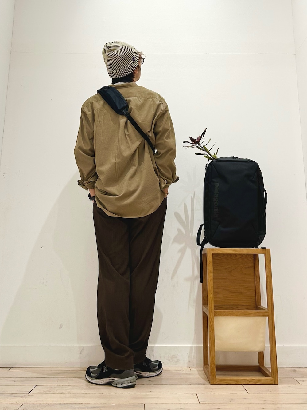 ブラック系のショルダーバッグ、ブラック系のスニーカー、ブラウン系のその他パンツを着用したメンズの秋コーディネートの4枚目の写真