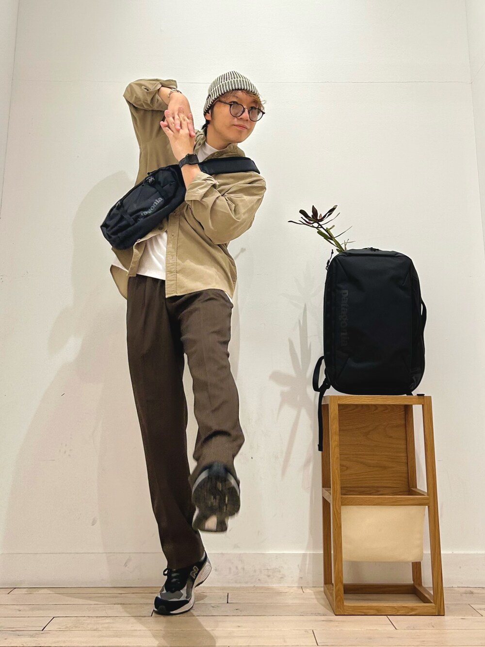 ブラック系のショルダーバッグ、ブラック系のスニーカー、ブラウン系のその他パンツを着用したメンズの秋コーディネートの2枚目の写真