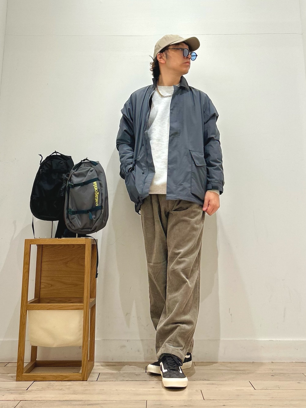 グレー系のナイロンジャケット、グレー系のスウェット、ブラウン系のその他パンツを着用したメンズの秋コーディネートの4枚目の写真