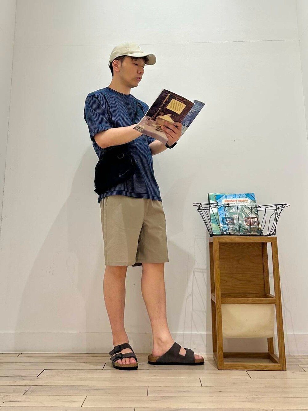 ブラック系のショルダーバッグ、ベージュ系のその他パンツ、ブルー系のTシャツ/カットソーを着用したメンズの夏コーディネートの3枚目の写真