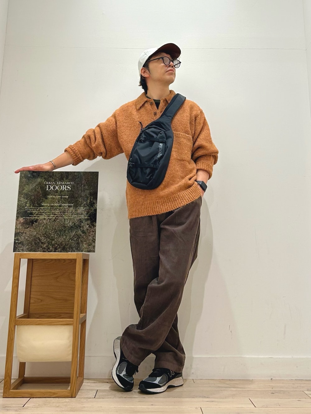 ブラック系のTシャツ/カットソー、ブラック系のショルダーバッグ、グリーン系のニット/セーターを着用したメンズの秋コーディネートの4枚目の写真