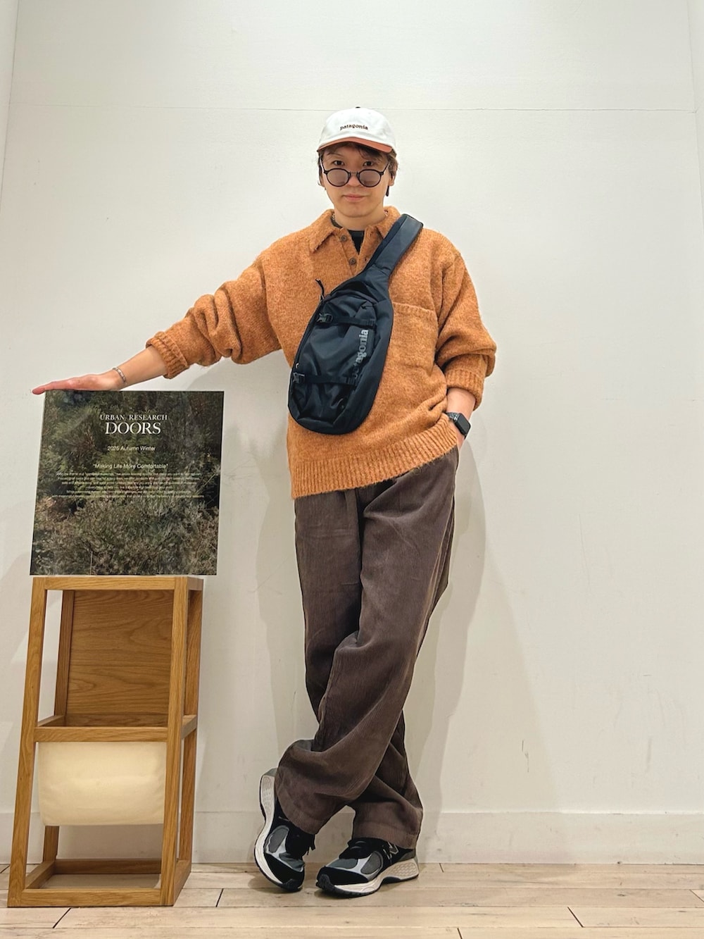 ブラック系のTシャツ/カットソー、ブラック系のショルダーバッグ、グリーン系のニット/セーターを着用したメンズの秋コーディネートの3枚目の写真