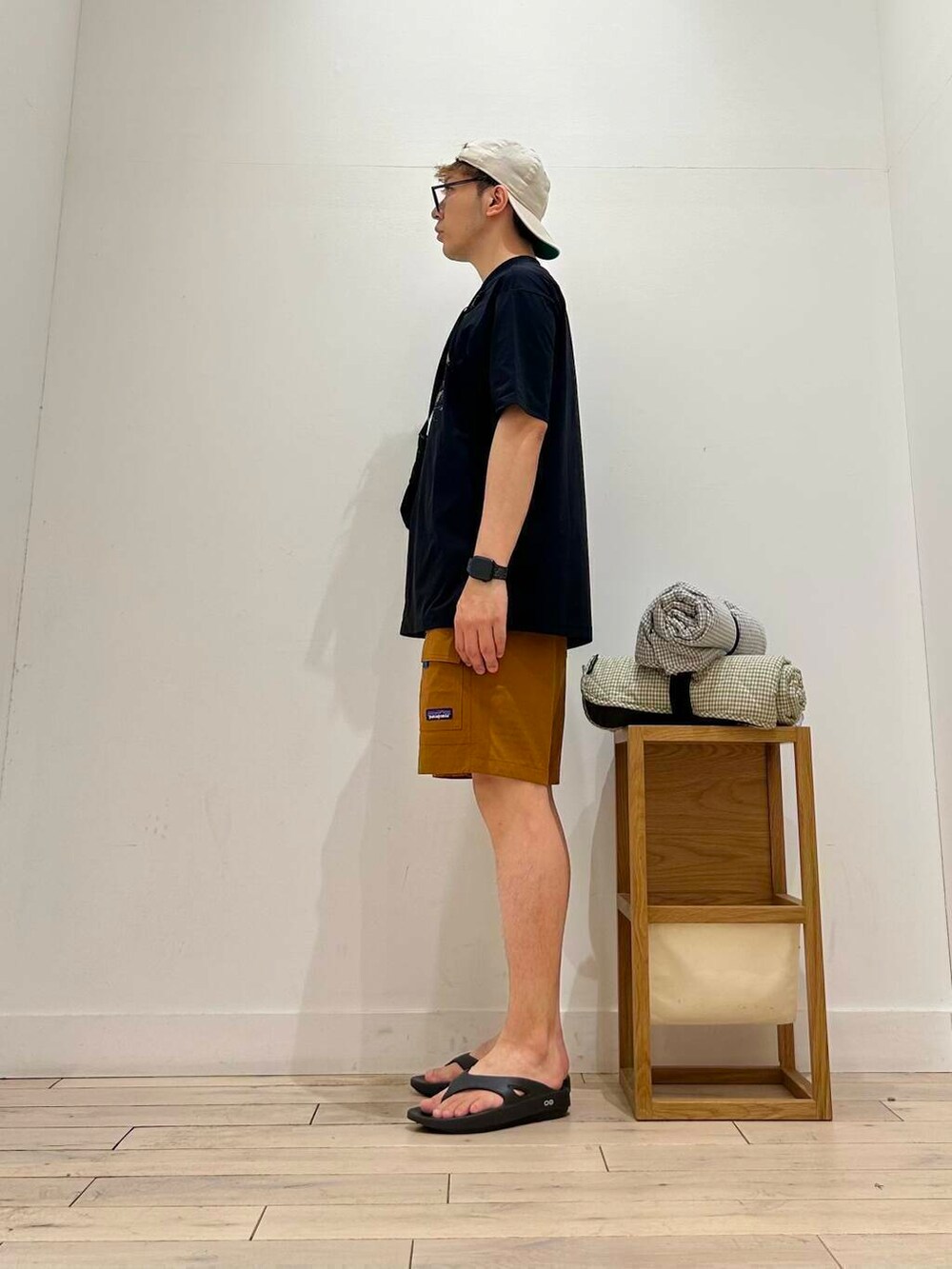 ブラック系のサンダル、ブラック系のTシャツ/カットソー、パープル系のラグ/マットを着用したメンズの夏コーディネートの2枚目の写真