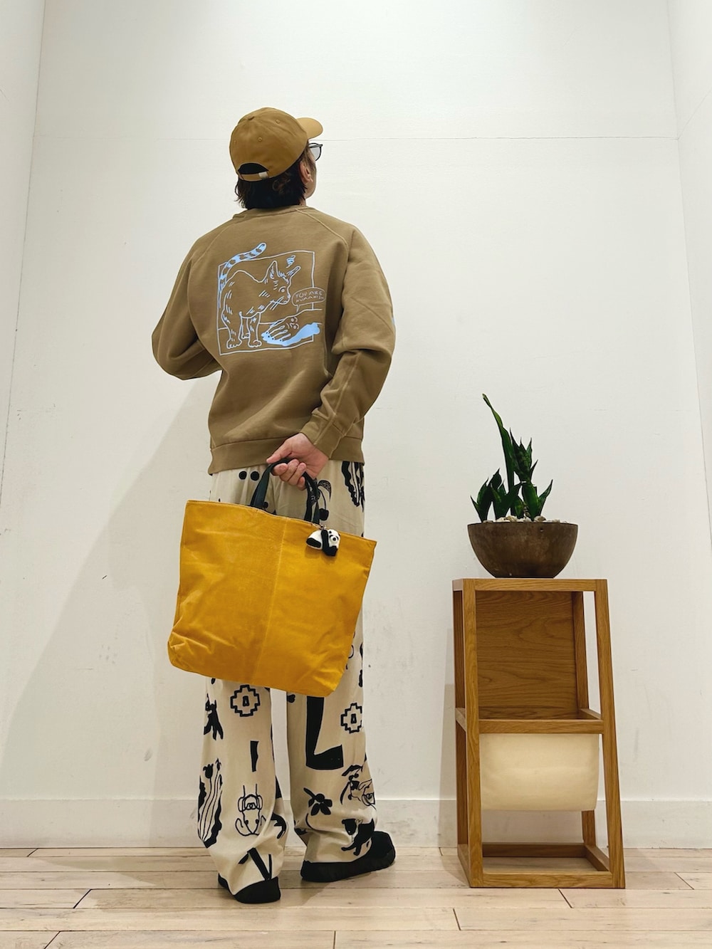 ホワイト系のその他パンツ、ブラック系のスリッポン、イエロー系のトートバッグを着用したメンズの秋コーディネートの5枚目の写真