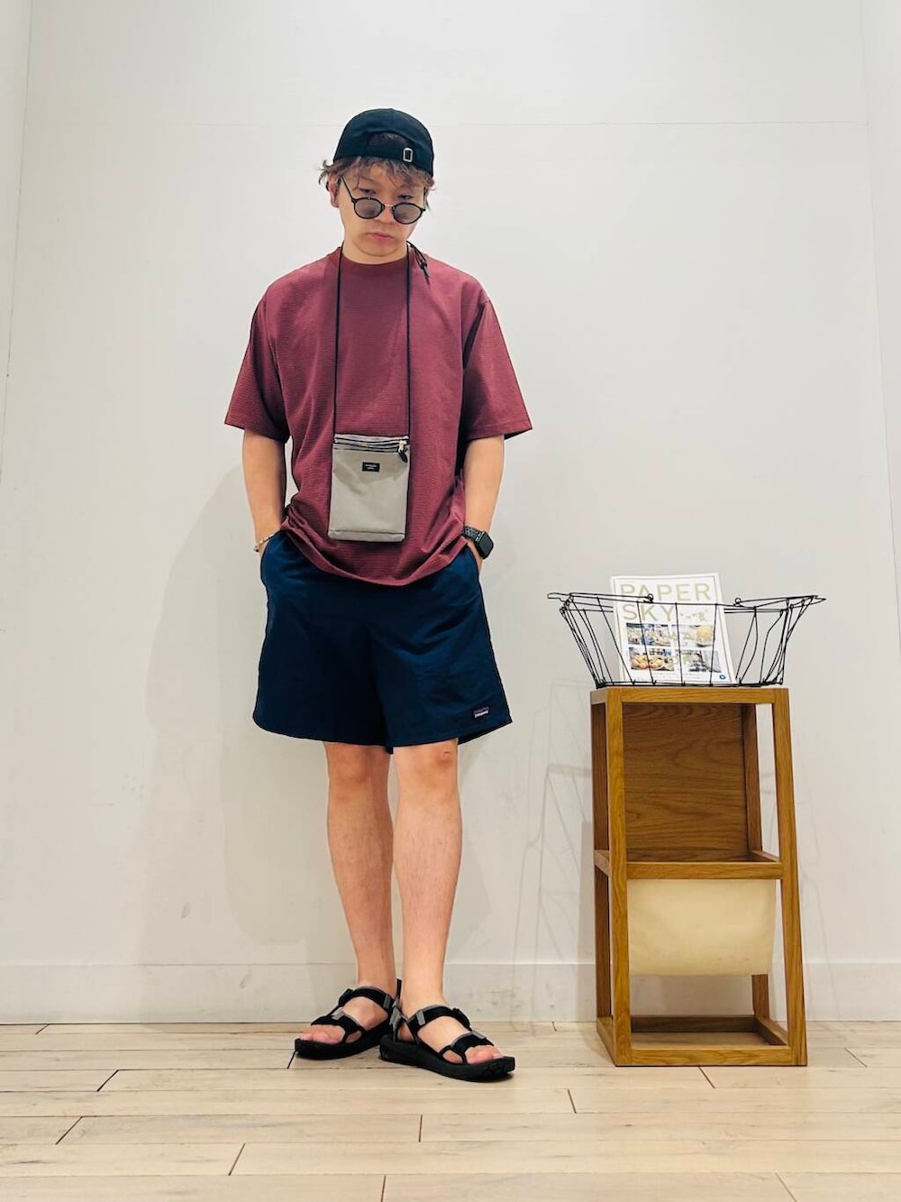 グレー系のショルダーバッグ、ブラック系のサンダル、オレンジ系のTシャツ/カットソーを着用したメンズの夏コーディネートの3枚目の写真