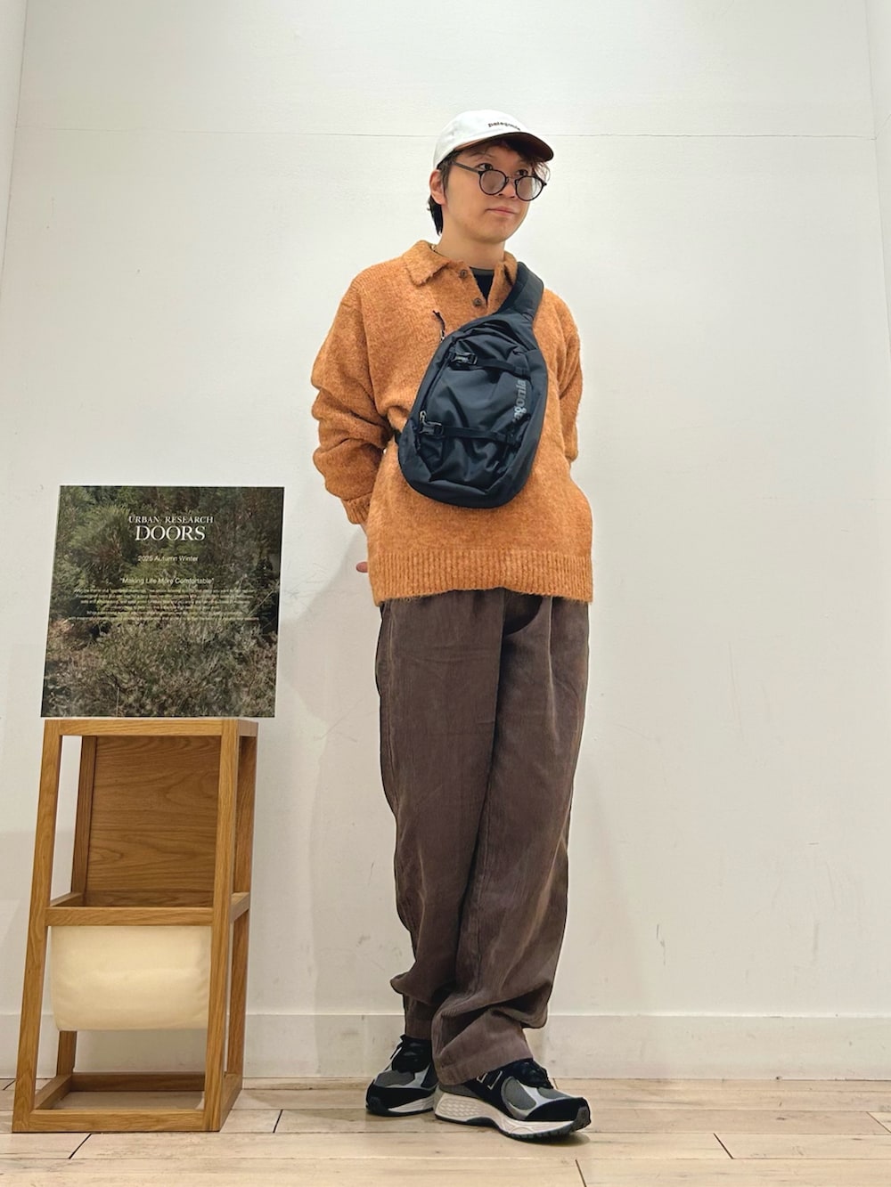ブラック系のTシャツ/カットソー、ブラック系のショルダーバッグ、グリーン系のニット/セーターを着用したメンズの秋コーディネートの2枚目の写真