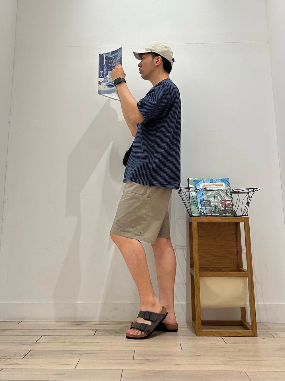 ブラック系のショルダーバッグ、ベージュ系のその他パンツ、ブルー系のTシャツ/カットソーを着用したメンズの夏コーディネートの4枚目の写真