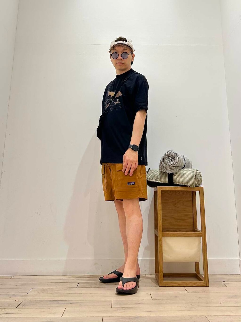 ブラック系のサンダル、ブラック系のTシャツ/カットソー、パープル系のラグ/マットを着用したメンズの夏コーディネートの4枚目の写真