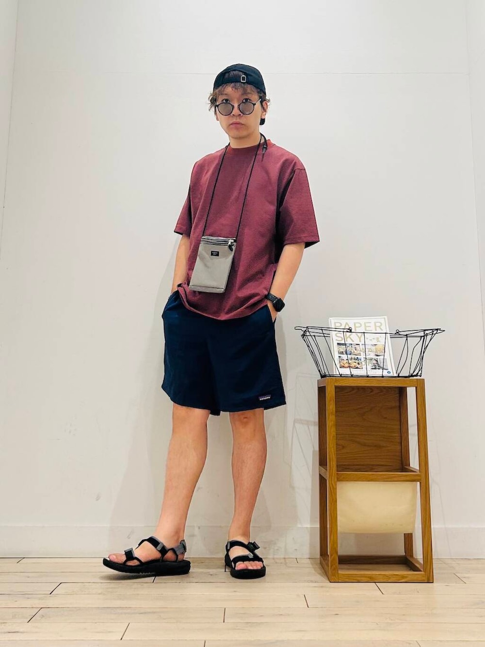 グレー系のショルダーバッグ、ブラック系のサンダル、オレンジ系のTシャツ/カットソーを着用したメンズの夏コーディネートの2枚目の写真