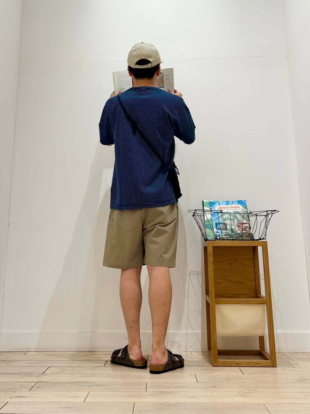 ブラック系のショルダーバッグ、ベージュ系のその他パンツ、ブルー系のTシャツ/カットソーを着用したメンズの夏コーディネートの5枚目の写真