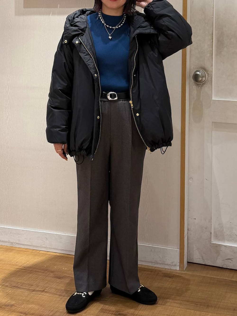 ブラック系のダウンジャケット/コート、ブルー系のニット/セーター、グレー系のその他パンツを着用したレディースの冬コーディネートの2枚目の写真