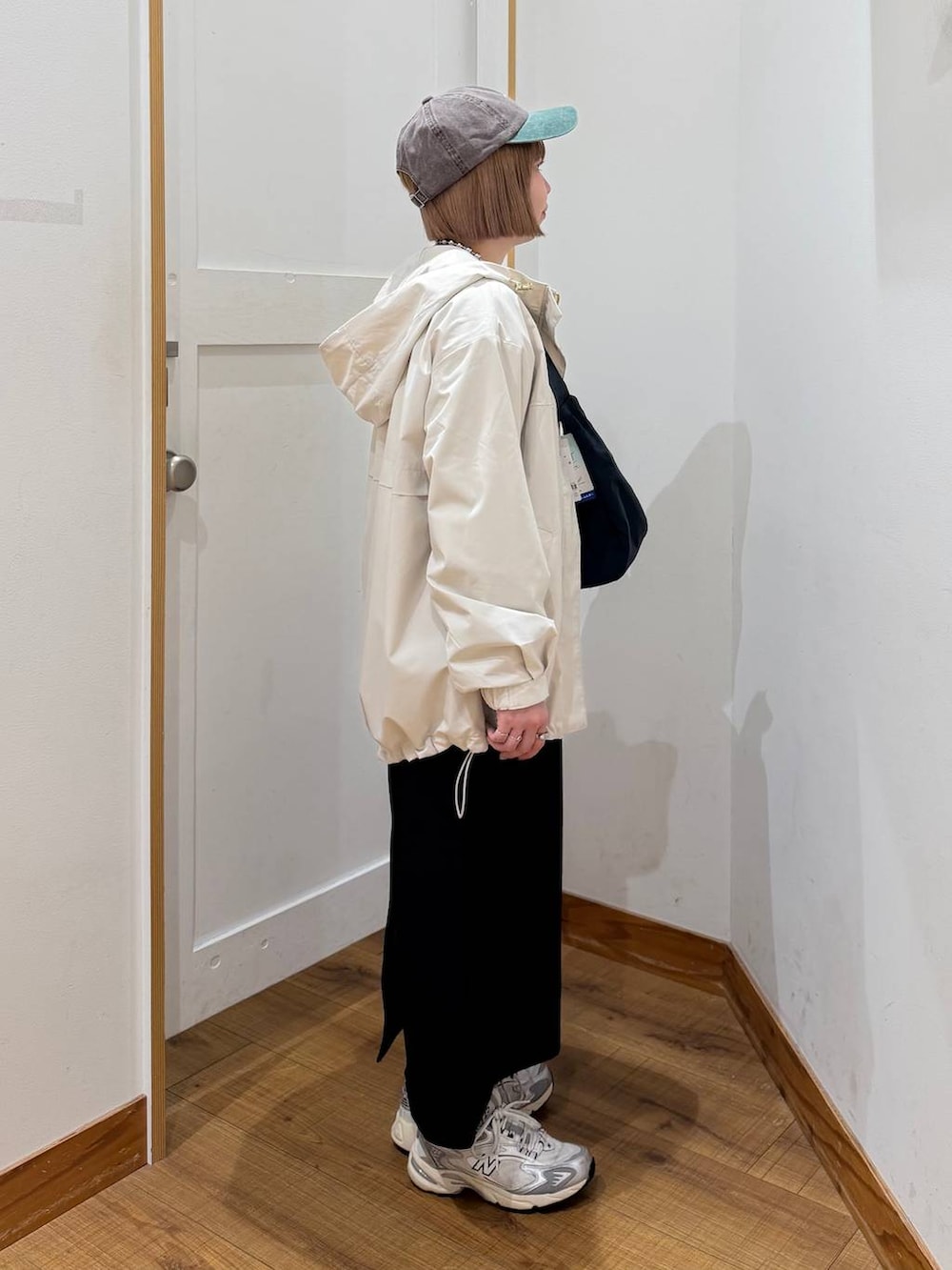 グレー系のスウェット、ベージュ系のマウンテンパーカー、グリーン系のショルダーバッグを着用したレディースの冬コーディネートの5枚目の写真